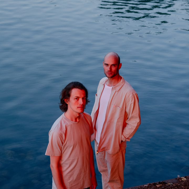 The duo standing at the edge of a lake